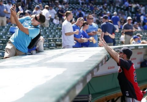 Aug 21, 2015; Chicago, IL, USA; Atlanta Braves first baseman Nick Swisher (23) poses for a selfie with a fan before the baseball game against the Chicago Cubs at Wrigley Field. Mandatory Credit: Kamil Krzaczynski-USA TODAY Sports