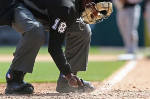 Apr 24, 2016; Detroit, MI, USA; MLB umpire Ramon De Jesus cleans off home plate during the game of the Cleveland Indians against the Detroit Tigers at Comerica Park. The Indians won 6-3. Mandatory Credit: Aaron Doster-USA TODAY Sports