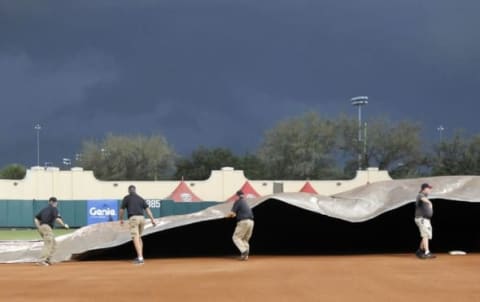 Mar 24, 2016; Lake Buena Vista, FL, USA; Ground crews cover the infield as a thunderstorm approaches during the fourth inning of a spring training baseball game between the Atlanta Braves and the Philadelphia Phillies at Champion Stadium. Mandatory Credit: Reinhold Matay-USA TODAY Sports