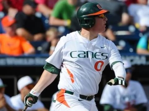 Jun 15, 2015; Omaha, NE, USA; Miami Hurricanes catcher Zack Collins (0) watches a ball in the 2015 College World Series at TD Ameritrade Park. Mandatory Credit: Steven Branscombe-USA TODAY Sports