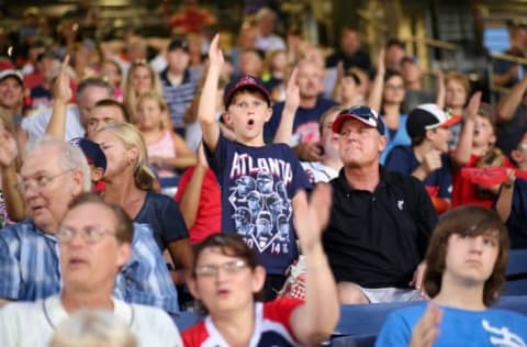 Jul 21, 2014; Atlanta, GA, USA; Atlanta Braves fan Maddox Lee (7 years old), from Greenwood, S.C., does the tomahawk chop during the game against the Miami Marlins at Turner Field. The Marlins won 3-1 in extra innings. Mandatory Credit: Kevin Liles-USA TODAY Sports