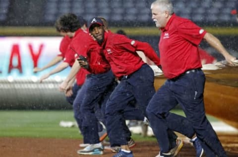 Apr 22, 2016; Atlanta, GA, USA; Atlanta Braves grounds crew members pull the tarp over the infield during a rain delay against the New York Mets in the eighth inning at Turner Field. Mandatory Credit: Brett Davis-USA TODAY Sports