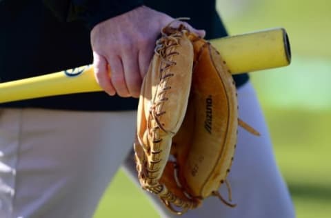 Feb 25, 2015; Mesa, AZ, USA; A mitt and bat are carried during an Oakland Athletics workout at Fitch Park. Mandatory Credit: Joe Camporeale-USA TODAY Sports