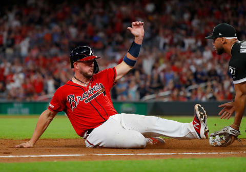 ATLANTA, GEORGIA – AUGUST 30: Tyler  Flowers #25 of the Atlanta Braves slides safely into third base against Yoan  Moncada #10 of the Chicago White Sox on a two-RBI single hit by Adeiny Hechavarria #24 in the seventh inning at SunTrust Park on August 30, 2019 in Atlanta, Georgia. (Photo by Kevin C. Cox/Getty Images)