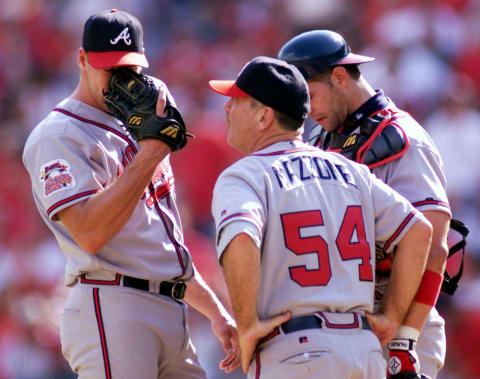 Atlanta Braves relief pitcher John Rocker (L) wipes his face during a visit to the mound by coach Leo Mazzone. AFP PHOTO/Mike FIALA (Photo by Mike FIALA / AFP) (Photo by MIKE FIALA/AFP via Getty Images)