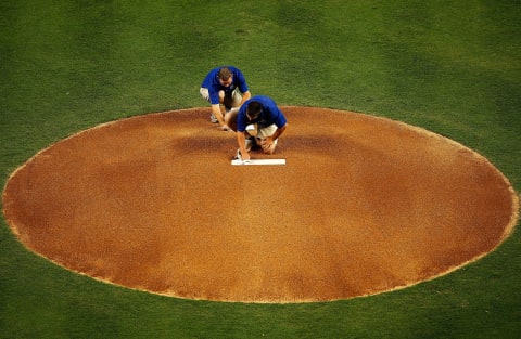 MIAMI, FL – APRIL 01: Members of the grounds crew clean the pitcher’s rubber before a game between the Miami Marlins and the New York Yankees at Marlins Park on April 1, 2012 in Miami, Florida. (Photo by Mike Ehrmann/Getty Images)