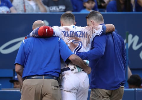 TORONTO, ON – JULY 28: Troy Tulowitzki #2 of the Toronto Blue Jays is helped off the field by trainers George Poulis and Mike Frostad after injuring his ankle in the third inning during MLB game action against the Los Angeles Angels of Anaheim at Rogers Centre on July 28, 2017 in Toronto, Canada. (Photo by Tom Szczerbowski/Getty Images)