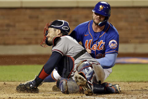 Pete Alonso of the New York Mets scores a run as he collides with Travis d’Arnaud of the Atlanta Braves at Citi Field on August 6, 2022. (Photo by Adam Hunger/Getty Images)