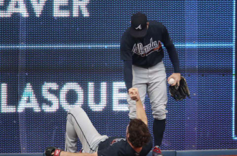 TORONTO, ON – JUNE 19: Charlie Culberson #16 of the Atlanta Braves is helped up by Ender Inciarte #11 after making a catch and crashing into the wall in the first inning during MLB game action against the Toronto Blue Jays at Rogers Centre on June 19, 2018 in Toronto, Canada. (Photo by Tom Szczerbowski/Getty Images)