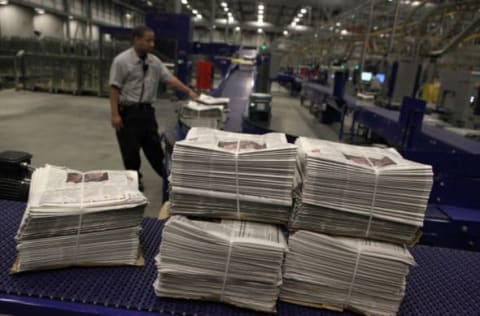 FREMONT, CA – NOVEMBER 08: A Transcontinental Printing worker monitors a conveyor belt carrying bundles of freshly printed copies of the new glossy San Francisco Chronicle November 8, 2009 in Fremont, California. (Photo by Justin Sullivan/Getty Images)