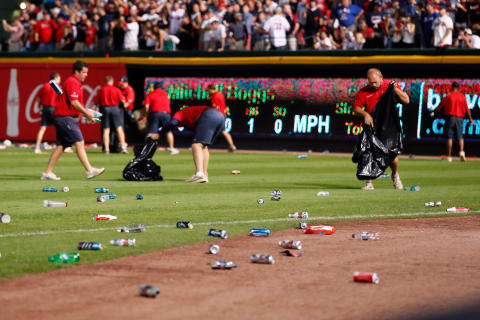 ATLANTA, GA – OCTOBER 05: Grounds crew members clean up bottles and cups thrown by fans after the home fans disagree with an infield fly ruling on a ball hit by Andrelton Simmons