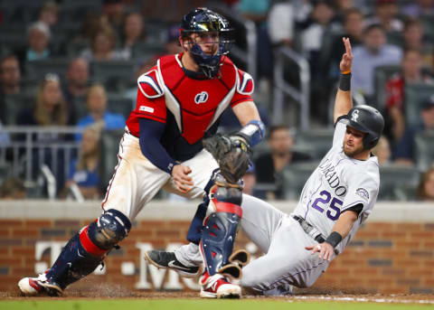 ATLANTA, GA – APRIL 26: Drew Butera #25 of the Colorado Rockies slides in to score behind Tyler Flowers #25 of the Atlanta Braves in the seventh inning of an MLB game at SunTrust Park on April 26, 2019 in Atlanta, Georgia. (Photo by Todd Kirkland/Getty Images)