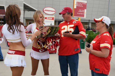 Aug 28, 2015; Kansas City, MO, USA; Kansas City Chiefs cheerleaders autograph a calendar for Lori Dobrisky (right) and Shannon Dubrisky (center) before the game against the Tennessee Titans at Arrowhead Stadium. Mandatory Credit: John Rieger-USA TODAY Sports