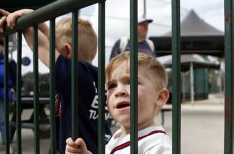 Feb 15, 2017; Lake Buena Vista, FL, USA; A small Atlanta Braves fan watches players walk by through a gate during MLB spring training workouts at Champion Stadium. Mandatory Credit: Reinhold Matay-USA TODAY Sports