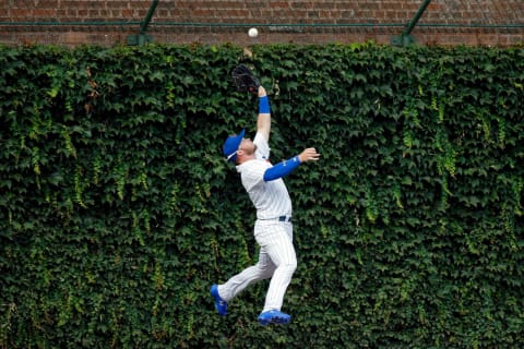 CHICAGO, IL – AUGUST 15: Ian Happ #8 of the Chicago Cubs makes a leaping catch for an out against the Milwaukee Brewers and collides with the outfield wall during the ninth inning at Wrigley Field on August 15, 2018 in Chicago, Illinois. The Chicago Cubs won 8-4. (Photo by Jon Durr/Getty Images)