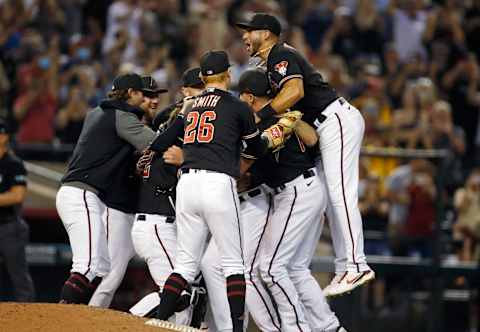 PHOENIX, ARIZONA – AUGUST 14: David Peralta #6 of the Arizona Diamondbacks (R) leaps on teammates as they surround pitcher Tyler Gilbert #49 of the Diamondbacks in celebration of his no hitter against the San Diego Padres during the MLB game at Chase Field on August 14, 2021 in Phoenix, Arizona. The Diamondbacks defeated the Padres 7-0. (Photo by Ralph Freso/Getty Images)