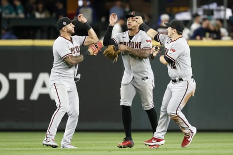 SEATTLE, WASHINGTON – SEPTEMBER 11: David Peralta #6, Ketel Marte #4 and Daulton Varsho #12 of the Arizona Diamondbacks react after beating the Seattle Mariners 7-3 at T-Mobile Park on September 11, 2021 in Seattle, Washington. (Photo by Steph Chambers/Getty Images)