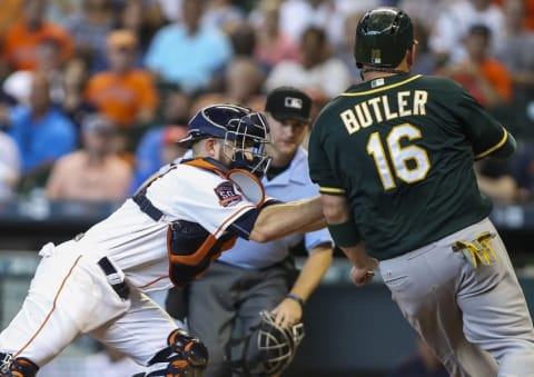 Sep 20, 2015; Houston, TX, USA; Houston Astros catcher Max Stassi (12) tags out Oakland Athletics first baseman Billy Butler (16) on a play at the plate during the second inning at Minute Maid Park. Mandatory Credit: Troy Taormina-USA TODAY Sports