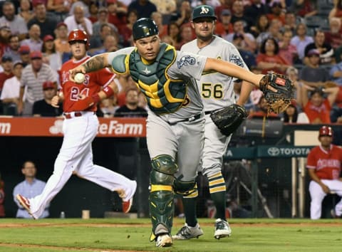 Sep 28, 2016; Anaheim, CA, USA; Oakland Athletics catcher Bruce Maxwell (63) mishandles an infield hit by Los Angeles Angels catcher Jett Bandy (13) allowing first baseman C.J. Cron (24) to score in the fourth inning of the game at Angel Stadium of Anaheim. Mandatory Credit: Jayne Kamin-Oncea-USA TODAY Sports