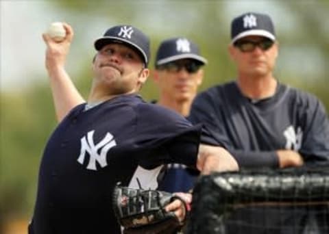 Feb 20, 2013; Tampa, FL, USA; New York Yankees pitcher Joba Chamberlain (left) throws batting practice during spring training at Steinbrenner Field. Mandatory Credit: John Munson/THE STAR-LEDGER via USA TODAY Sports