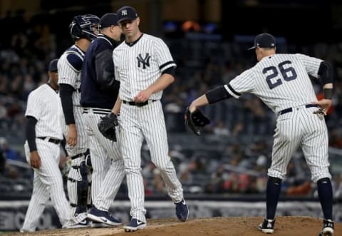 NEW YORK, NEW YORK – MAY 09: Manager Aaron Boone #17 of the New York Yankees pulls J.A. Happ #34 from the game as teammate DJ LeMahieu #26 consoles him in the sixth inning against the Seattle Mariners at Yankee Stadium on May 09, 2019 in the Bronx borough of New York City. (Photo by Elsa/Getty Images)