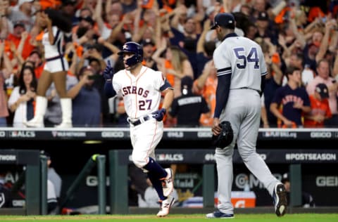 HOUSTON, TEXAS - OCTOBER 19: Jose Altuve #27 of the Houston Astros comes home to score following his ninth inning walk-off two-run home run as Aroldis Chapman #54 of the New York Yankees walks off the field in game six of the American League Championship Series at Minute Maid Park on October 19, 2019 in Houston, Texas. The Astros defeated the Yankees 6-4. (Photo by Elsa/Getty Images)