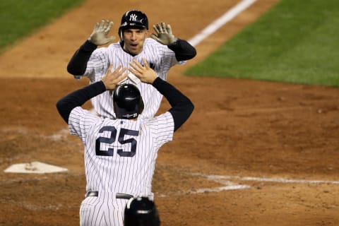 NEW YORK, NY – OCTOBER 13: Mark Teixeira #25 and Raul Ibanez #27 of the New York Yankees celebrate after they both scored on a 2-run home run hit by Ibanez in the bottom of the ninth inning against the Detroit Tigers during Game One of the American League Championship Series at Yankee Stadium on October 13, 2012 in the Bronx borough of New York City, New York. (Photo by Alex Trautwig/Getty Images)