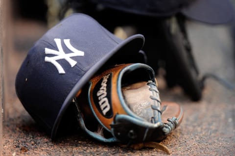 A New York Yankees cap and glove on the dugout steps during the game against the Baltimore Orioles (Photo by G Fiume/Getty Images)