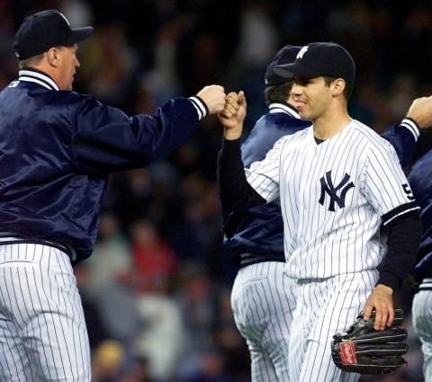 New York Yankees left fielder Ricky Ledee (R) is congratulated by pitching coach Mel Stottlemyre (L) after the Yankees beat the Texas Rangers 3-1 in game two of the American League Division Series 07 October, 1999 (Photo by TIMOTHY A. CLARY/AFP via Getty Images)