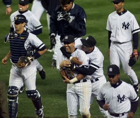 New York Yankees Luis Sojo (C) gets a hug from Jose Vizcaino at the end of the Yankees game against the Oakland Athletics during the American League Division Series 06 October, 2000 (Photo by DOUG KANTER/AFP via Getty Images)