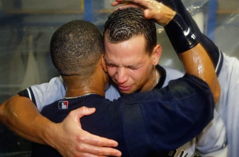 Alex Rodriguez #13 (R) hugs teammate Gary Sheffield #11 of the New York Yankees during a locker room celebration after defeating the Minnesota Twins (Photo by Jed Jacobsohn/Getty Images)