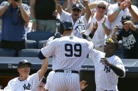 NEW YORK, NY - AUGUST 13: Aaron Judge #99 of the New York Yankees is greeted by manager Joe Girardi #28 and Didi Gregorius #18 after he hit a home run in his first MLB at bat during the second inning of a game against the Tampa Bay Rays at Yankee Stadium on August 13, 2016 in the Bronx borough of New York City. (Photo by Rich Schultz/Getty Images)