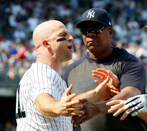 Brett Gardner #11 of the New York Yankees is held back by coach Marcus Thames #62 (Photo by Paul Bereswill/Getty Images)