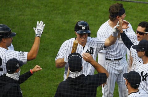 NEW YORK, NEW YORK - AUGUST 29: The New York Yankees high-five Erik Kratz #42 (C) after his at-bat where he attempted to bunt, allowing teammate Clint Frazier #42 (not pictured) to score on a wild pitch during the ninth inning against the New York Mets at Yankee Stadium on August 29, 2020 in the Bronx borough of New York City. The Yankees won 2-1. All players are wearing #42 in honor of Jackie Robinson Day. The day honoring Jackie Robinson, traditionally held on April 15, was rescheduled due to the COVID-19 pandemic. (Photo by Sarah Stier/Getty Images)