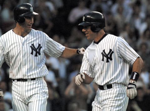 NEW YORK, UNITED STATES: New York Yankees’s Scott Brosius (R) is congratulated by Paul O’Neill (L) after driving him home with a two-run homer in the fourth inning against the Atlanta Braves 08 June 2001 in New York. AFP PHOTO/Doug KANTER (Photo credit should read DOUG KANTER/AFP via Getty Images)