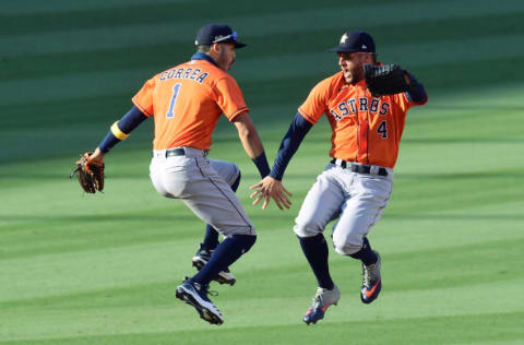 LOS ANGELES, CALIFORNIA - OCTOBER 06: George Springer #4 and Carlos Correa #1 of the Houston Astros celebrate a 5-2 win against the Oakland Athletics in Game Two of the American League Division Series at Dodger Stadium on October 06, 2020 in Los Angeles, California. (Photo by Harry How/Getty Images)