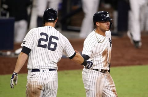 SAN DIEGO, CALIFORNIA - OCTOBER 08: Gleyber Torres #25 of the New York Yankees is congratulated by DJ LeMahieu #26 after scoring a run against the Tampa Bay Rays during the eighth inning in Game Four of the American League Division Series at PETCO Park on October 08, 2020 in San Diego, California. (Photo by Christian Petersen/Getty Images)