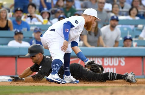 LOS ANGELES, CA - AUGUST 25: Justin Turner #10 of the Los Angeles Dodgers takes the throw as Brett Gardner #11 of the New York Yankees is safe at third on a throwing error by relief pitcher Adam Kolarek #56 of the Los Angeles Dodgers in the ninth inning of the game against the Los Angeles Dodgers at Dodger Stadium on August 25, 2019 in Los Angeles, California. Teams are wearing special color schemed uniforms with players choosing nicknames to display for Players' Weekend. (Photo by Jayne Kamin-Oncea/Getty Images)