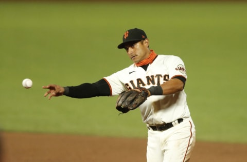 SAN FRANCISCO, CALIFORNIA - SEPTEMBER 22: Donovan Solano #7 of the San Francisco Giants fields the ball against the Colorado Rockies at Oracle Park on September 22, 2020 in San Francisco, California. (Photo by Lachlan Cunningham/Getty Images)