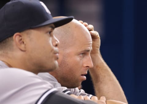 TORONTO, ON – JULY 6: Brett Gardner #11 of the New York Yankees and Giancarlo Stanton #27 look on from the top step of the dugout during MLB game action against the Toronto Blue Jays at Rogers Centre on July 6, 2018 in Toronto, Canada. (Photo by Tom Szczerbowski/Getty Images)