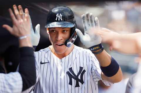 NEW YORK, NEW YORK - MAY 23: Aaron Judge #99 of the New York Yankees high-fives teammates after scoring on a two-RBI single hit by Gleyber Torres #25 (not pictured) during the first inning against the Chicago White Sox at Yankee Stadium on May 23, 2021 in the Bronx borough of New York City. (Photo by Sarah Stier/Getty Images)