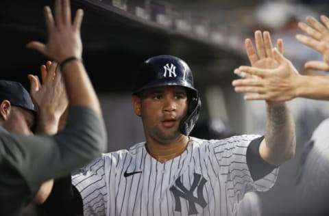 NEW YORK, NEW YORK - JUNE 29: Gary Sanchez #24 of the New York Yankees high-fives teammates after scoring on a two-RBI double hit by Luke Voit #59 (not pictured) during the fourth inning against the Los Angeles Angels at Yankee Stadium on June 29, 2021 in the Bronx borough of New York City. (Photo by Sarah Stier/Getty Images)