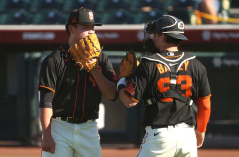 SCOTTSDALE, ARIZONA - MARCH 28: Kai-Wei Teng #82 and Patrick Bailey #93 of the San Francisco Giants have a conversation after getting into a jam in the ninth inning against the Oakland Athletics in an MLB spring training game at Scottsdale Stadium on March 28, 2021 in Scottsdale, Arizona. (Photo by Abbie Parr/Getty Images)