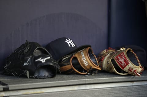 NEW YORK, NY - JUNE 6: A baseball hat and gloves are seen in the New York Yankees dugout (Photo by Adam Hunger/Getty Images)