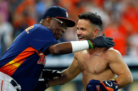 HOUSTON, TEXAS - JULY 11: Manager Dusty Baker Jr. #12 of the Houston Astros hugs Jose Altuve after hitting a three run walk off home run in the ninth inning to beat the New York Yankees 8-7 at Minute Maid Park on July 11, 2021 in Houston, Texas. (Photo by Bob Levey/Getty Images)