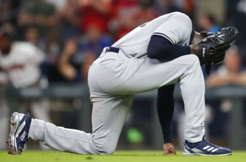 ATLANTA, GA - AUGUST 24: Aroldis Chapman #54 of the New York Yankees punches the ground in frustration after walking a batter in the ninth inning against the Atlanta Braves at Truist Park on August 24, 2021 in Atlanta, Georgia. (Photo by Todd Kirkland/Getty Images)