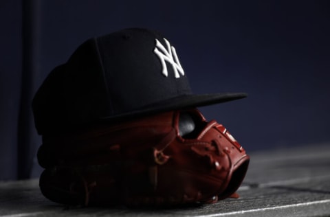 NEW YORK, NY - JUNE 6: A New York Yankees baseball hat sits on top of a glove in the Yankee dugout against the Boston Red Sox during the eighth inning at Yankee Stadium on June 6, 2021 in the Bronx borough of New York City. (Photo by Adam Hunger/Getty Images)