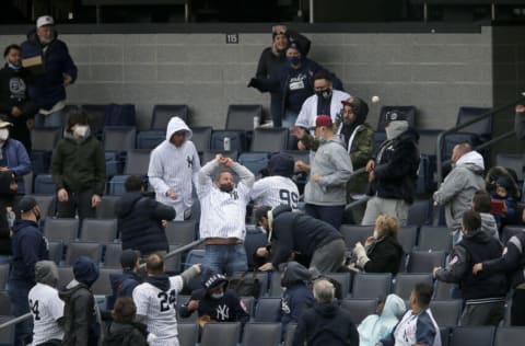 NEW YORK, NEW YORK - APRIL 01: (NEW YORK DAILIES OUT) Fans reach for a foul ball during a game between the New York Yankees and the Toronto Blue Jays at Yankee Stadium on April 01, 2021 in New York City. The Blue Jays defeated the Yankees 3-2 in ten innings. (Photo by Jim McIsaac/Getty Images)