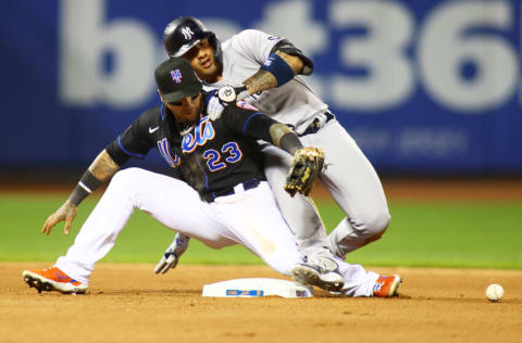 NEW YORK, NEW YORK - SEPTEMBER 10: Gleyber Torres #25 of the New York Yankees slides in for a doubles as the ball gets away from Javier Baez #23 of the New York Mets in the seventh inning at Citi Field on September 10, 2021 in New York City. (Photo by Mike Stobe/Getty Images)