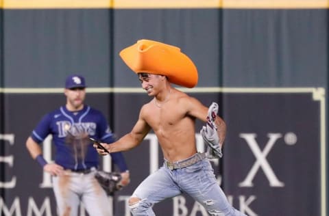 HOUSTON, TEXAS - SEPTEMBER 29: A fan runs onto the field in the ninth inning during a game between the Tampa Bay Rays and Houston Astros at Minute Maid Park on September 29, 2021 in Houston, Texas. (Photo by Bob Levey/Getty Images)